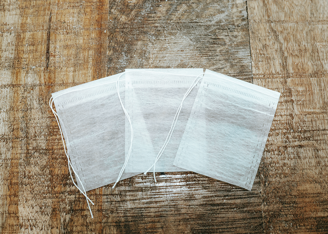 biodegradable drawstring tea bags from IngenuiTea™ on counter